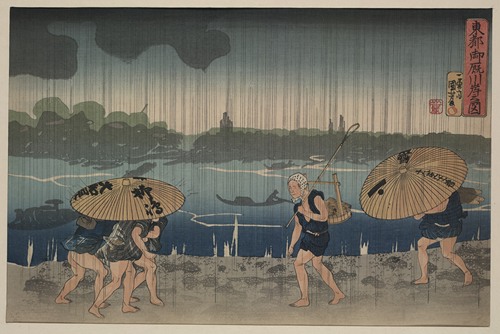 People walking beneath umbrellas along the seashore during a rainstorm