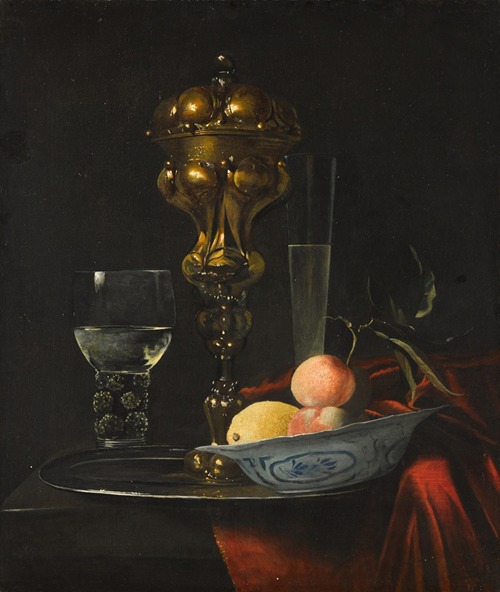 Still life with a gilt cup on a silver plate, a porcelain bowl with fruit, a roemer, and a wine glass, all on a wooden table draped in red fabric