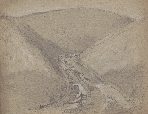 Village in mountain gap, train running on tracks on the left, buildings on strip of land dividing a river
