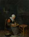 An elderly woman scaling fish in an interior