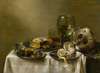 A still life with an overturned silver tazza, glassware, pies and a peeled lemon on a table
